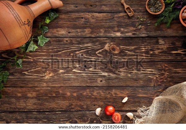 Wooden\
background in rustic style with copy space. Food background in\
georgian style with ingredients, jug for wine and grape leaf.\
Georgian food menu. Wooden table with empty\
place