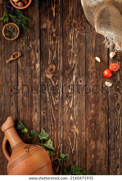 Wooden\
background in rustic style with copy space. Food background in\
georgian style with ingredients, jug for wine and grape leaf.\
Georgian food menu. Wooden table with empty\
place