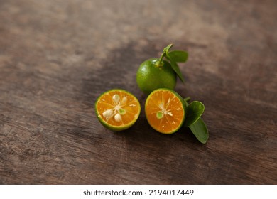 Wooden Background Sliced  Kumquat And Leaf