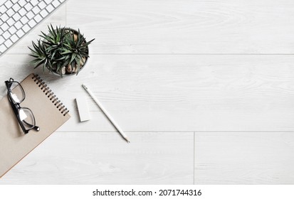 Wooden Background With Stationery. Overhead Above View Photo Of Notebook, Succulent Plant, Glasses, Pencil, Eraser And Keyboard. Copy Space For Your Text. Flat Lay.