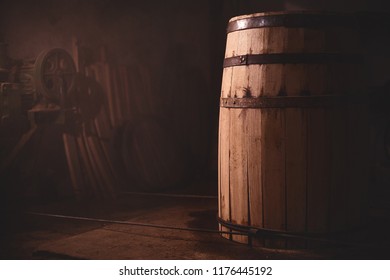 Wooden Barrel On A Dark Background, In A Workshop, In An Old Room. Production Of Barrels For Cognac And Wine, In A Low Key