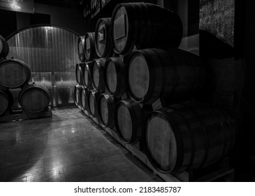 Wooden Barrels Of Aged Wine. Old Wine Cellar With Many Oak Barrels, Equipment For Wine Production. Barrels In Cellar. Rows Of Wine And Cognac Barrels In The Basement Of Winery. Process Of Aging