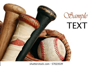 Wooden baseball bats with ball and glove on white background with copy space.  Macro with shallow dof.  Focus on taped handle.