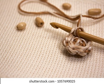 Wooden Beads And Embroidery Hook On The Aida Fabric Background