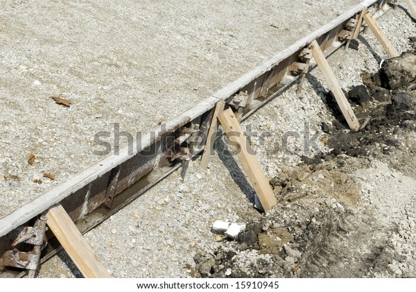 Wooden\
beams supporting cement on a construction\
site.