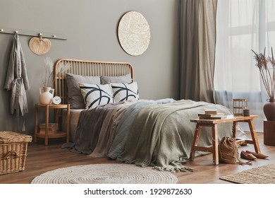 Wooden Bed In Stylish Neutral Bedroom Interior With Design Furniture, Decoration, Carpet, Bench, Dried Flowers In Vase, Bed Sheets, Blanket, Pillows And Elegant Personal Accessories In Home Decor.