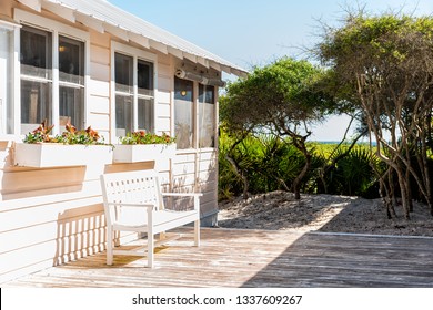 Wooden bench and cottage home house architecture in Florida beach by sand dunes during sunny day peaceful tranquil vacation