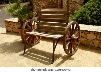 A wooden bench made using two wagon wheels