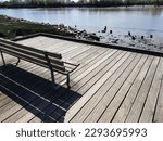 Wooden bench next to the river in Fraser River Park in Vancouver BC Canada