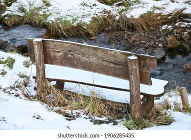 A Wooden Bench On A Snowy Hillside