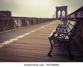 Wooden Bench On The Walkway At Brooklyn Bridge And The Fog In Dark Vintage Style