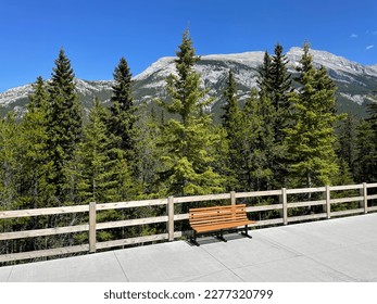 wooden bench in the park with a view of the snow-capped mountains. Banff, Alberta, Canada - Shutterstock ID 2277320799