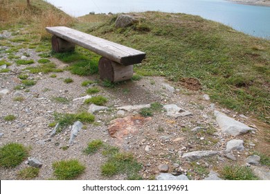 Wooden Bench, Bench At The Reservoir Monte Spluga, At The Splügen Pass, And Surrounding Mountains In Summer 