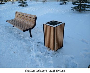 wooden bench and trash can in city park in winter. High quality photo