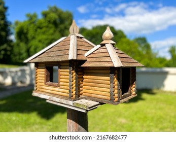 Wooden bird feeder in the form of a house with bait	