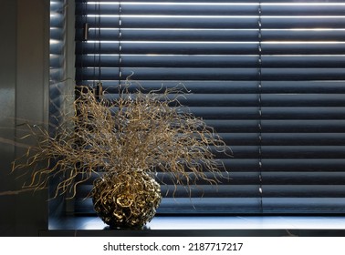 Wooden blinds black color closeup on the window. Bamboo slats 50mm wide. Venetian wood blinds in the kitchen. Round vase gold color is on the windowsill.