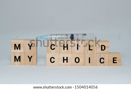 Wooden block creating the word my child my choice and injection syringe. Anti-vax society have cause new problem in medical industry.