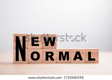 Wooden block cubes for new normal wording. The world is changing to balance it into new normal include business , economy , environment and health.