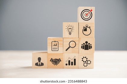 Wooden block cude step on a table with Action Plan, Goal, and Target icons. Success and business target concept. Project management and company strategy for financial growth. - Shutterstock ID 2316488843