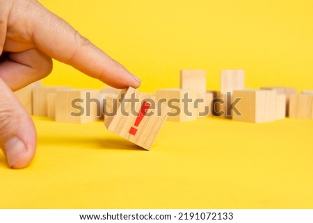 wooden block in exclamation mark on yellow table background, wood cube concept mean not entirely lost all sense of proportion extreme emotion, such as excitement, shock, order, admiration