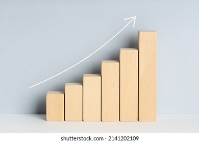 Wooden Block Financial Bar Chart Graph With Upward Trend Line Drawn On Background. Growing Business Concept