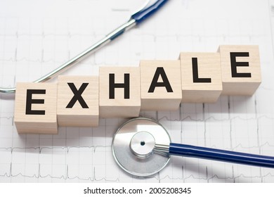 Wooden Block Form The Word Exhale With Stethoscope On The Doctor's Desktop. Medical Concept. Healthcare Conceptual For Hospital, Clinic And Medical Business