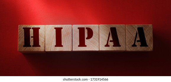 Wooden block form the word HIPAA Health Insurance Portability and Accountability Act on red. Medical concept.