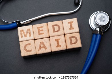 Wooden Block Form The Word MEDICAID With Stethoscope. Medical Concept.