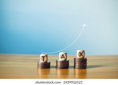 Wooden block on a coin with a tax icon with an arrow rising on the coin Investment ideas and interest rates Higher financial graphs and statistics.