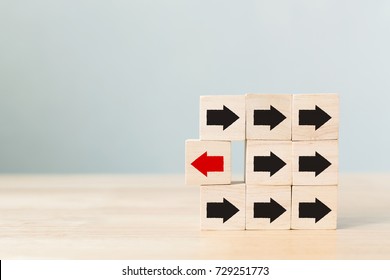 Wooden block with red arrow facing the opposite direction black arrows, Unique, think different, individual and standing out from the crowd concept - Shutterstock ID 729251773