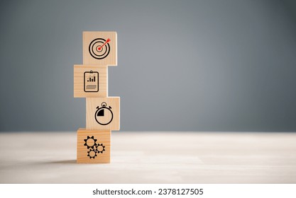 Wooden block step on a table with Action Plan, Goal, and Target icons. Success and business target concept. Company strategy and project management for financial growth.