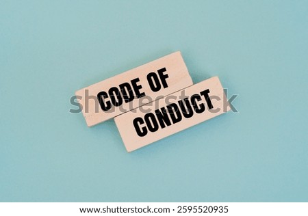 A wooden block with text CODE OF CONDUCT against colour background