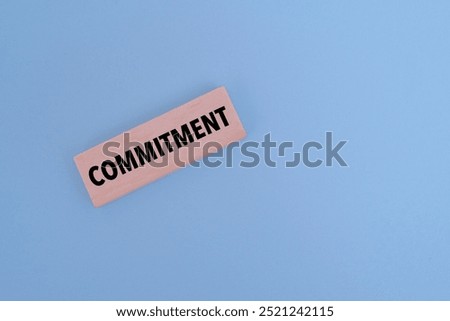 A wooden block with text COMMITMENT on it