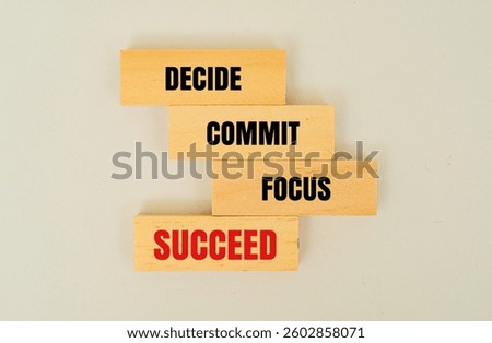 A wooden block with word DECIDE, COMMIT, FOCUS, SUCCEED
