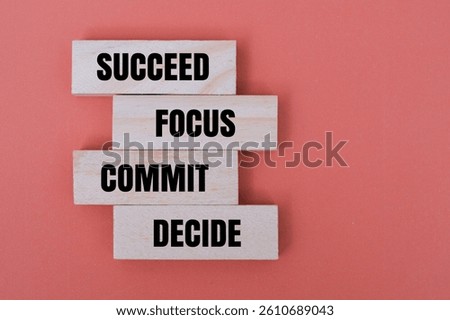 A wooden block with word DECIDE, COMMIT, FOCUS, SUCCEED