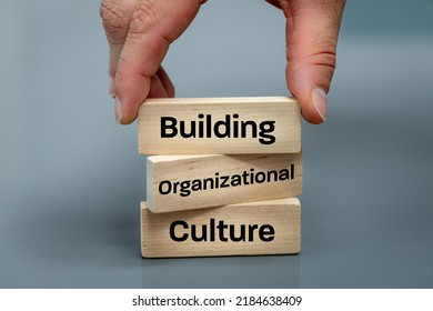 A wooden block with the words Building, Organizational, Culture, Modern approach to working with people in a team, Creative concept