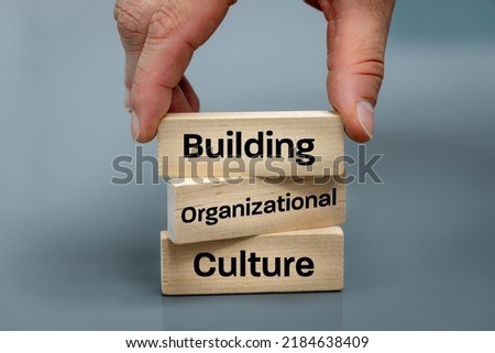 A wooden block with the words Building, Organizational, Culture, Modern approach to working with people in a team, Creative concept