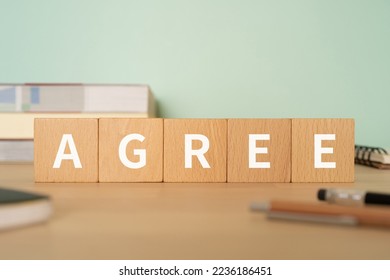 Wooden blocks with "AGREE" text of concept, pens, notebooks, and books. - Shutterstock ID 2236186451