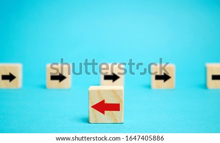 Wooden blocks with arrows. Individual opinion concept. Stand out from the crowd. Uniqueness. Divergent views. Different concepts to other people. Business metaphor