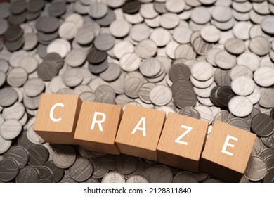 Wooden blocks with "CRAZE" text of concept and coins.