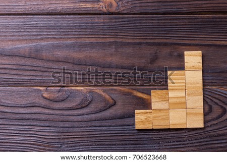 A wooden blocks cube over black wooden textured background with copy space for add word text title. Concept or conceptual Wood block stair or four steps. Cubic.