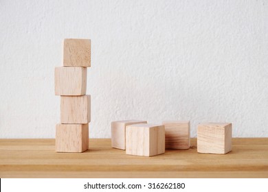 Wooden blocks, cubes on wood table over white cement wall background