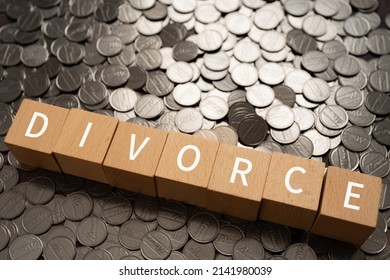 Wooden blocks with "DIVORCE" text of concept and coins.