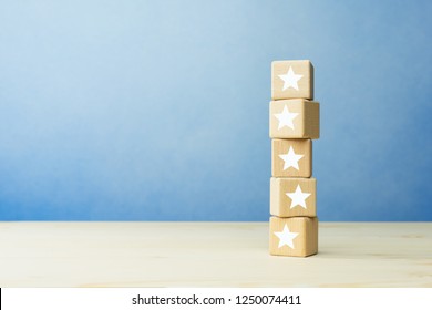 Wooden blocks with the five star symbol on the table, evaluation, Increase rating, Customer experience, satisfaction and best excellent services rating concept.