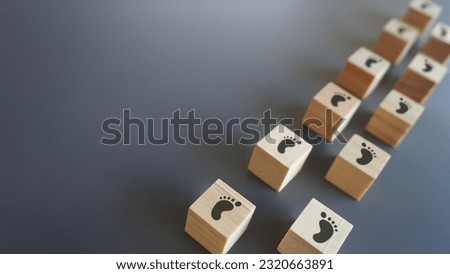 Wooden blocks with footsteps icon and copy space. Progress, step by step, journey, process concept