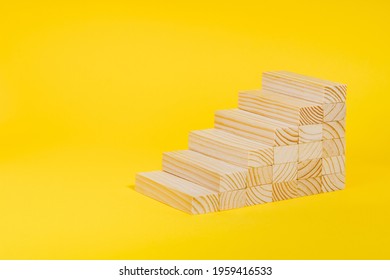 Wooden blocks forming stairway on yellow background. Personal growth, business career path concept. Ladder of success, investment, development .