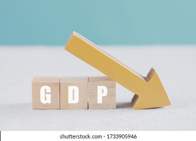 Wooden Blocks With GDP Word And Yellow Down Arrow, Impacts Of Covid-19 Global Economy Financial Crisis, Gross Domestic Product Falling Concept