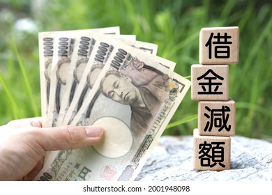 Wooden blocks with Japanese writing on them. Business words about debt reduction. Translation: debt reduction. - Shutterstock ID 2001948098