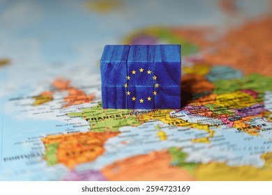 Wooden blocks painted with the European Union EU flag placed on a Europe map, symbolizing European unity, integration, politics, and economy. High quality photo