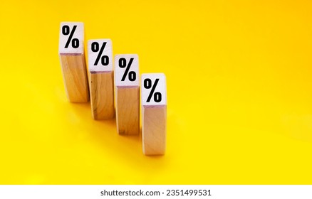 Wooden blocks with percent sign on yellow background